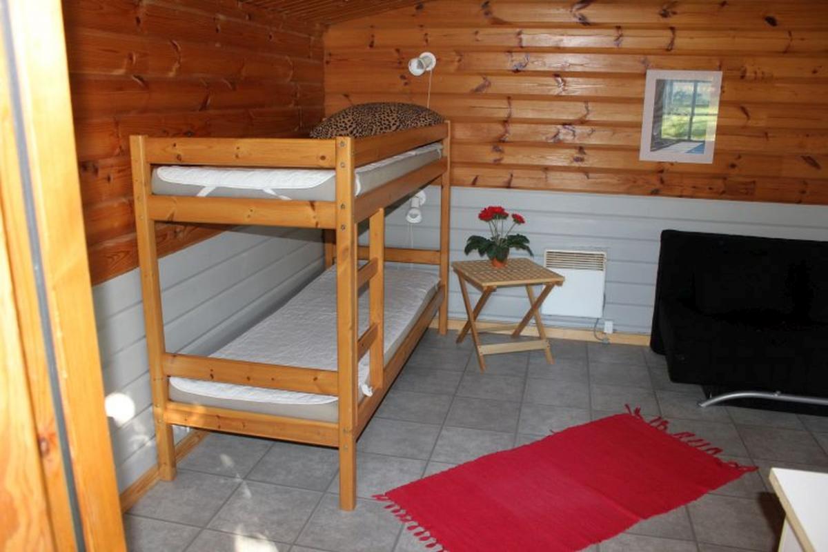 Bjælkehytte med terrasse. indrettet med køkkenbord med skabe ... Sovesofa som køjeseng