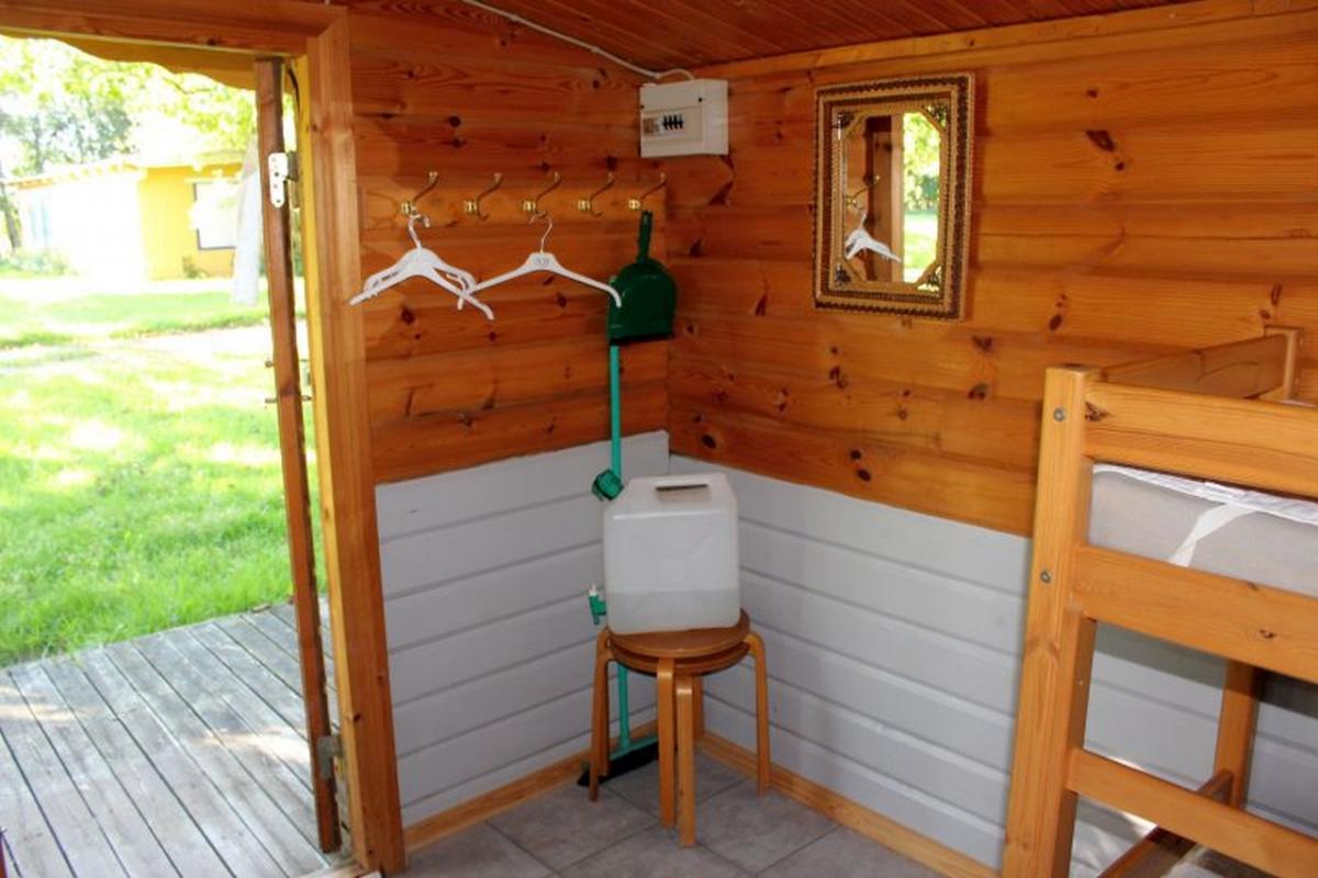 Bjælkehytte med terrasse. indrettet med køkkenbord med skabe ... Sovesofa som køjeseng